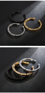 Macro shot of three adjustable C-shaped stainless steel bangles with geometric textures