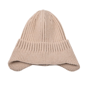 Dettaglio del cappello beige a coste con paraorecchie e trama termica invernale