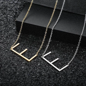 Close-up of a minimalist capital letter E pendant in gold and silver finish on O-chain
