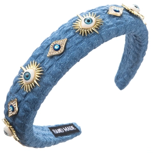 Detailed view of denim headband with evil eye charms and handmade inner label