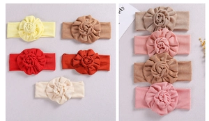 Macro detail of soft handmade fabric flower headbands for newborn babies in various colors