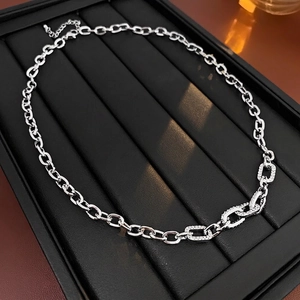 Silver tone chunky chain necklace with zircon square accents on a black jewelry tray