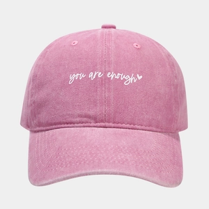 Detail of pink washed cotton baseball cap with white heart and handwritten lettering
