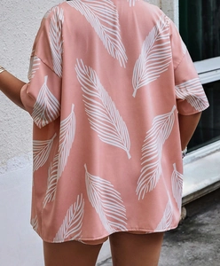 Detail of pink short-sleeve shirt with white feather leaf print from a back view