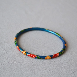 Detail of cloisonné enamel bangle with ginkgo floral patterns on blue brass base