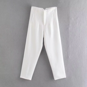 Close-up of white casual trousers featuring waist pleats and functional side pockets