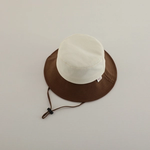 Detailed close-up of beige and brown contrast sun hat with adjustable windproof cord