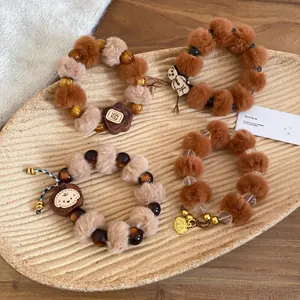 Bracelets mignons d'ours avec boules de fourrure d'automne et perles de bois sur plateau