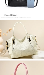 Detailed view of crocodile pattern textures and gold hardware on large tote bags