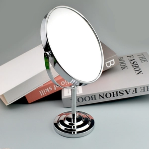Detail of round double-sided makeup mirror with a chrome metal stand and base