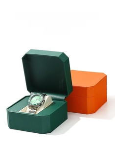 Detail view of octagonal PU leather watch boxes in dark green and orange showing custom textures