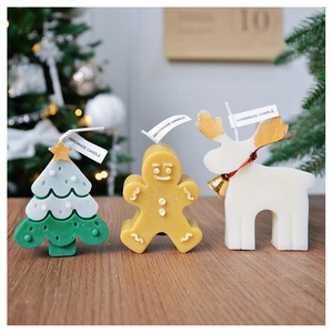 Detail of handmade Christmas candles in tree, gingerbread man, and elk shapes on wood