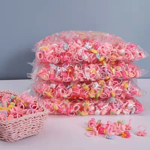 Bulk pack of pink plastic cartoon rings for girls in bags and a small woven basket