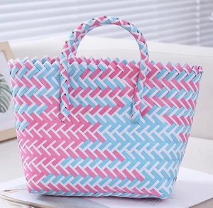 Close-up of pink and blue hand-woven basket showing colorful geometric checkered pattern