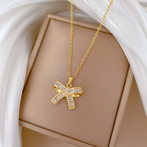 Close-up of golden butterfly pendant with rectangular zircons on a delicate chain
