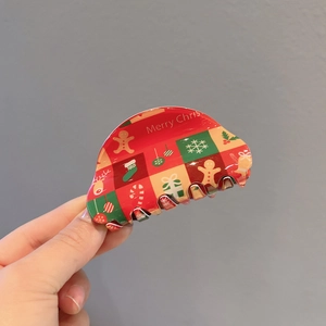 Close-up of Christmas hair claw featuring festive gingerbread and snowflake patterns