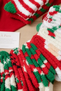 Nahaufnahme der flauschigen Korallenfleece-Weihnachtssocken mit rot-grün-weißen Streifen