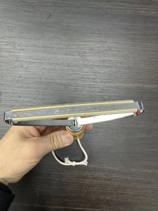 Macro view of portable manual lint remover with dual copper heads and wooden handle