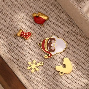 Detailed macro view of 18K gold plated Christmas enamel charms on a linen lining