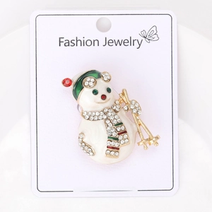 Détail de la broche bonhomme de neige de Noël avec bonnet vert, écharpe rouge et strass