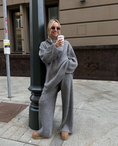 Detail of dark grey knit set featuring vertical ribbed texture on sweater and wide-leg pants