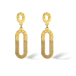 Close-up of golden geometric earrings with engraved star motif and matte texture