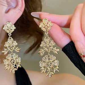 Elegant gold hollow flower tassel earrings with three-layer vintage floral design