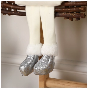 Détail des jambes d'une poupée en peluche avec bottes à paillettes argentées et fausse fourrure