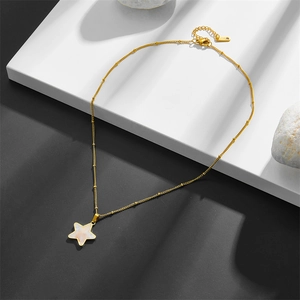Chic gold titanium star necklace with white shell inlay on a geometric display