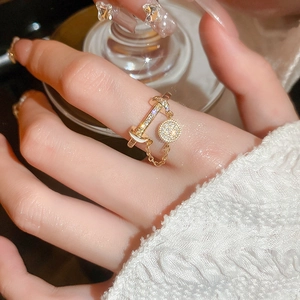 Detailansicht des champagnergoldenen Zirkonia-Rings mit Kettentropfen am Finger