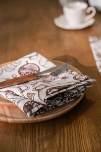 Detail of vintage hand-drawn pattern on beige cotton linen napkin over a wooden plate