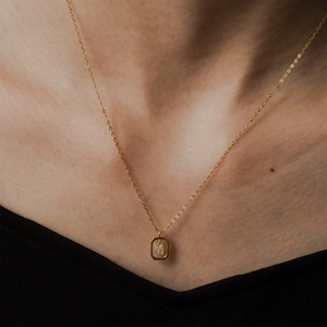 Close-up of a delicate S925 sterling silver gold-plated necklace with a letter M pendant