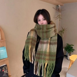 Detail of soft mohair plaid scarf with long tassels in green and yellow checks