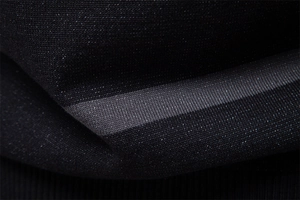 Vue macro montrant la texture du tissu en maille rayé noir et gris sur un pull pour homme