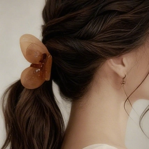 Pince à cheveux papillon ambrée élégante présentée dans une coiffure sur cheveux bruns