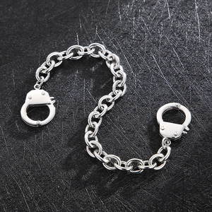 Macro view of stainless steel handcuffs charm with thick silver O-chain necklace