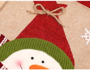 Detail of Christmas snowman gift bag featuring red burlap hat and green corduroy fabric