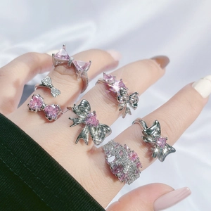Model wearing silver bow and pink crystal ring set with sparkling heart details