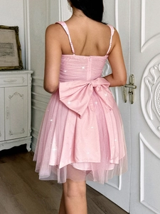 Detail of pink tulle dress featuring sparkly sequins and a large back bow detail