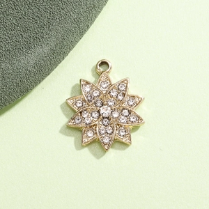 Detailed view of a gold snowflake charm pendant with crystal rhinestones for DIY jewelry