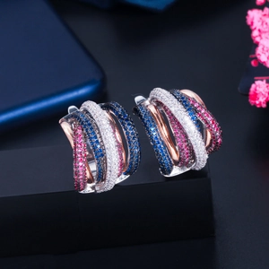 Macro shot of intertwined earrings featuring blue, red, and white cubic zirconia stones