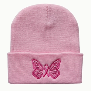 Close-up of pink butterfly and breast cancer ribbon embroidery on a knitted beanie hat
