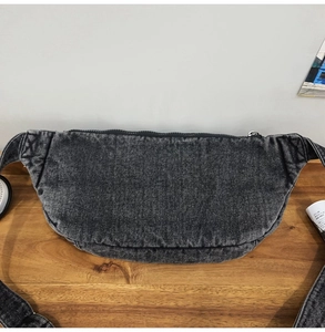 Detailed view of washed gray denim texture and stitching on this casual crossbody chest bag