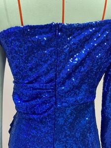 Dettaglio dell'abito con paillettes blu brillante con arricciatura laterale e zip invisibile