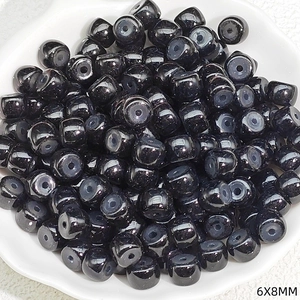 Macro shot of 6x8mm black polished barrel beads for DIY jewelry and beaded crafts
