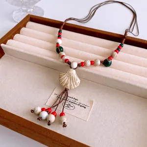 Bohemian multilayer ceramic fringe necklace with ivory shell pendant on brown cord