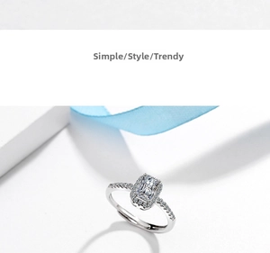 Macro detail of silver ring featuring a rectangular emerald cut stone and halo diamonds