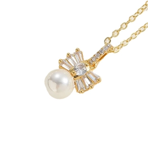 Elegant gold necklace with white pearl and fan-shaped zircon pendant on white background