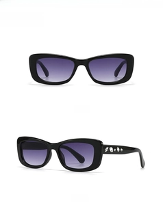 Close-up of small square sunglasses with crystal-embellished temples and purple lenses