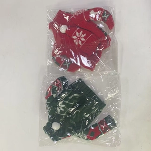 Detailed view of Christmas wine bottle covers with red and green knitted snowflake patterns